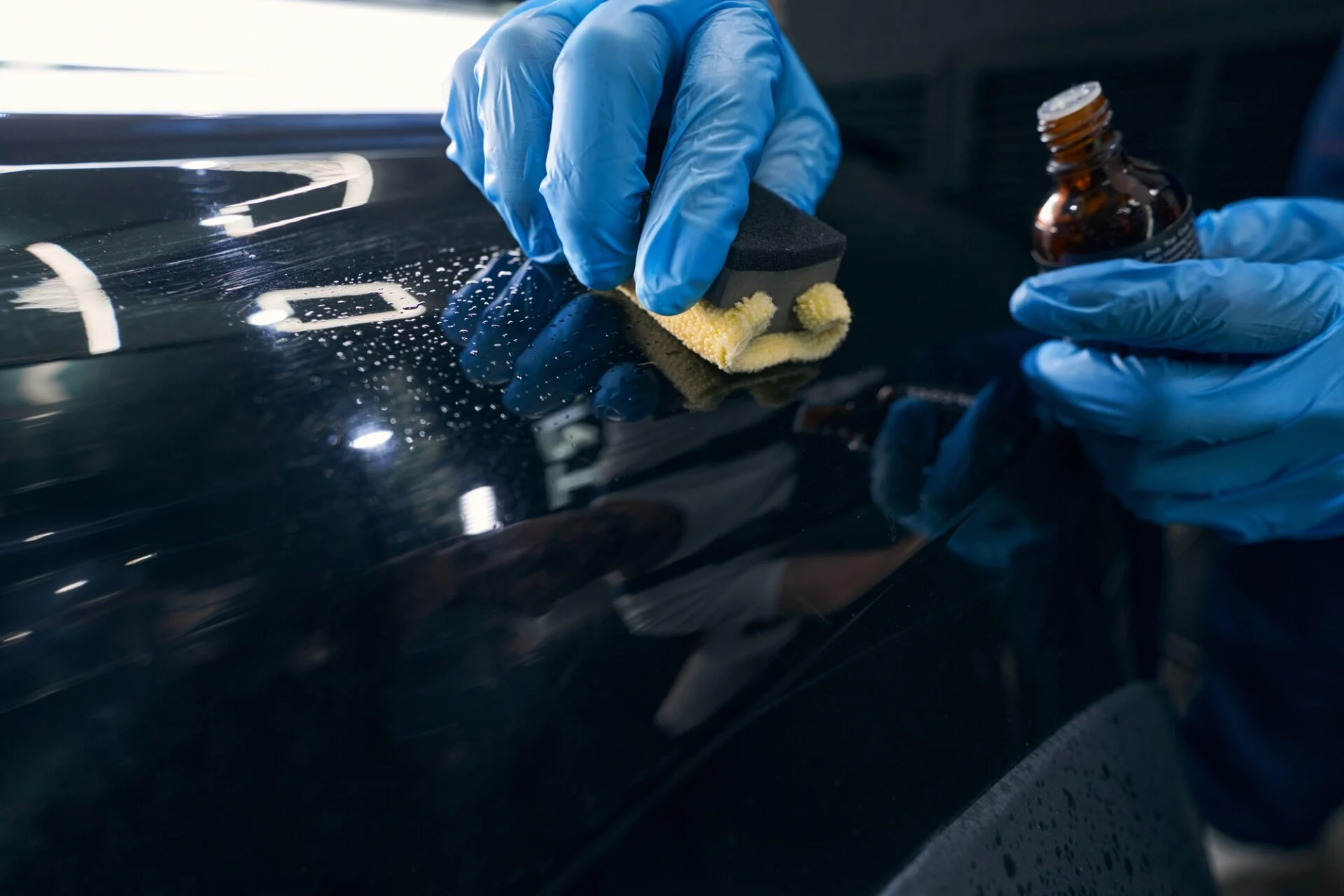 Repairman applying ceramic coating to car surface